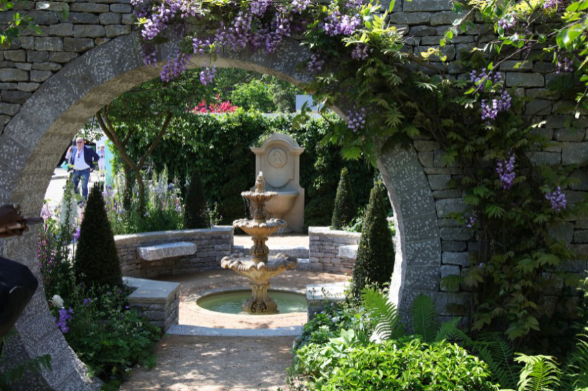 Une fontaine et des éléments décoratifs en pierre dans un jardin Regencycore